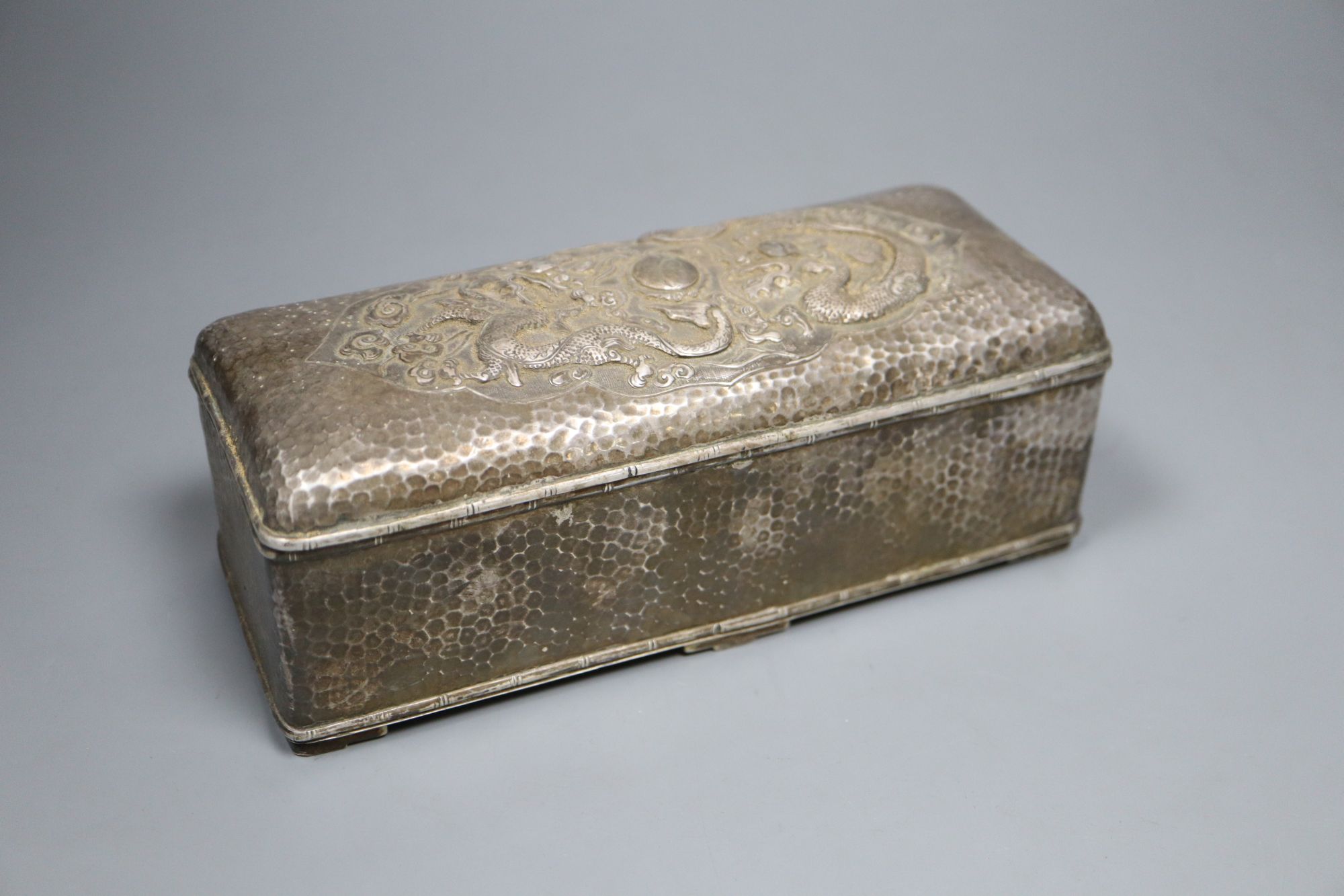 A Chinese planished silver casket, c.1900, with twin dragon decoration and divided interior, marks worn, 19cm